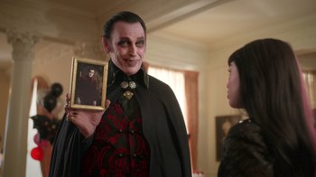 Movie still from “Monster High 2” (2023), directed by Todd Holland – A man holding a picture of a woman; Medium shot, Over the shoulder angle