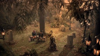 Movie still from “Monster High 2” (2023), directed by Todd Holland – A group of people sitting on a bench in the woods; Extreme Wide shot, High angle