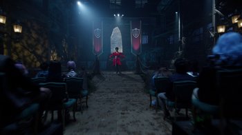 Movie still from “Monster High 2” (2023), directed by Todd Holland – A man in a red jacket standing in front of a group of people; Extreme Wide shot, Over the shoulder angle