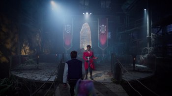 Movie still from “Monster High 2” (2023), directed by Todd Holland – Two people are standing in front of a stage; Wide shot, Over the shoulder angle