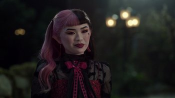 Movie still from “Monster High 2” (2023), directed by Todd Holland – A woman with pink and black hair wearing a black and pink outfit; Close Up shot, Over the shoulder angle
