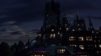 Movie still from “Monster High 2” (2023), directed by Todd Holland – A castle like building in the night time; Extreme Wide shot, Low angle