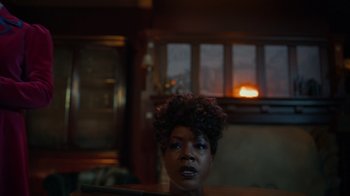 Movie still from “Monster High 2” (2023), directed by Todd Holland – A woman with curly hair looking out of a window; Close Up shot, Over the shoulder angle