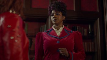 Movie still from “Monster High 2” (2023), directed by Todd Holland – A woman in a red coat and a blue and white striped shirt; Medium shot, Over the shoulder angle