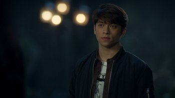 Movie still from “Monster High 2” (2023), directed by Todd Holland – A young man is standing in front of some lights; Close Up shot, Over the shoulder angle