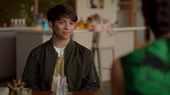 Movie still from “Monster High 2” (2023), directed by Todd Holland – A man sitting at a table in front of a chair; Close Up shot, Over the shoulder angle