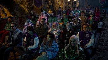 Movie still from “Monster High 2” (2023), directed by Todd Holland – A group of people sitting in a room; Wide shot, High angle