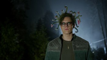 Movie still from “Monster High 2” (2023), directed by Todd Holland – A man wearing glasses and a green jacket with tentacles coming out of his head; Close Up shot, Low angle