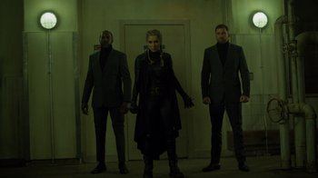 Movie still from “Monster High 2” (2023), directed by Todd Holland – A group of men standing next to each other in front of a door; Medium shot, Low angle