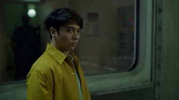 Movie still from “Monster High 2” (2023), directed by Todd Holland – A man in a yellow shirt is standing in front of a window; Close Up shot, Over the shoulder angle