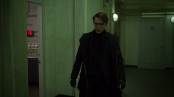 Movie still from “Monster High 2” (2023), directed by Todd Holland – A man in a black jacket is walking in a hallway; Medium shot, Low angle