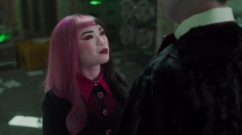 Movie still from “Monster High 2” (2023), directed by Todd Holland – A woman with pink and black hair wearing a black suit; Medium shot, Over the shoulder angle