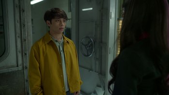 Movie still from “Monster High 2” (2023), directed by Todd Holland – A man in a yellow jacket standing in front of a mirror; Medium shot, Over the shoulder angle