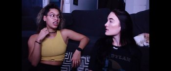 Movie still from “Monster Inside: America's Most Extreme Haunted House” (2023), directed by Andrew Renzi – Two women sitting on a couch talking to each other; Medium shot, Low angle