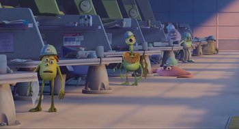 Movie still from “Monsters, Inc.” (2001), directed by Pete Docter – A group of cartoon characters standing in front of a computer desk; Extreme Wide shot, Over the shoulder angle