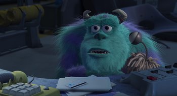Movie still from “Monsters, Inc.” (2001), directed by Pete Docter – A blue monster with horns is sitting at a desk; Medium shot, Over the shoulder angle