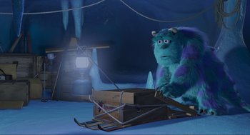 Movie still from “Monsters, Inc.” (2001), directed by Pete Docter – A blue monster is sitting on a sled in the snow; Extreme Wide shot, High angle