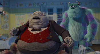 Movie still from “Monsters, Inc.” (2001), directed by Pete Docter – A man in a suit and tie next to a monster in a room; Medium shot, Low angle