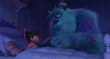 Movie still from “Monsters, Inc.” (2001), directed by Pete Docter – A little girl sitting next to a monster on top of a bed; Wide shot, Over the shoulder angle