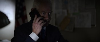 Movie still from “Monsters of Man” (2020), directed by Mark Toia – A man in a suit talking on a cell phone; Close Up shot, Low angle