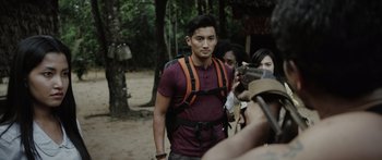 Movie still from “Monsters of Man” (2020), directed by Mark Toia – A man with a backpack is standing in the woods; Medium shot, Over the shoulder angle