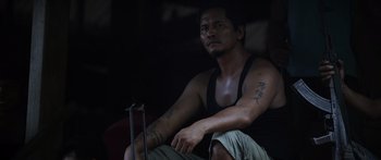 Movie still from “Monsters of Man” (2020), directed by Mark Toia – A man sitting on the ground in a dark room; Medium shot, Low angle