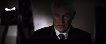 Movie still from “Monsters of Man” (2020), directed by Mark Toia – A person wearing a suit and tie; Close Up shot, Over the shoulder angle