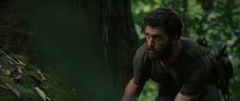 Movie still from “Monsters of Man” (2020), directed by Mark Toia – A man in the woods leaning against a tree; Close Up shot, Low angle