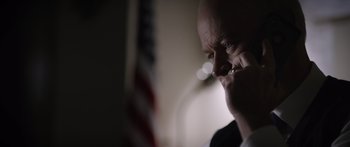 Movie still from “Monsters of Man” (2020), directed by Mark Toia – A man with a bald head is talking on a cell phone; Close Up shot, Low angle