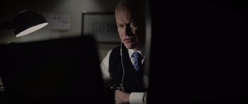 Movie still from “Monsters of Man” (2020), directed by Mark Toia – A man in a vest and tie looking at a computer screen; Close Up shot, Over the shoulder angle