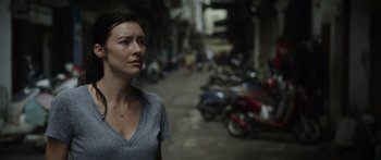 Movie still from “Monsters of Man” (2020), directed by Mark Toia – A woman standing on a street next to parked scooters; Close Up shot, Low angle