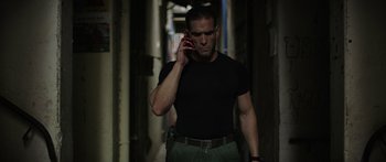 Movie still from “Monsters of Man” (2020), directed by Mark Toia – A man in black shirt talking on a cell phone; Medium shot, Low angle