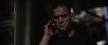 Movie still from “Monsters of Man” (2020), directed by Mark Toia – A person talking on a cell phone; Close Up shot, Low angle