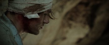 Movie still from “Monsters of Man” (2020), directed by Mark Toia – A person with a bandage on his head; Extreme Close Up shot, Low angle