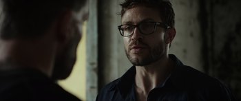 Movie still from “Monsters of Man” (2020), directed by Mark Toia – A person wearing glasses; Close Up shot, Over the shoulder angle