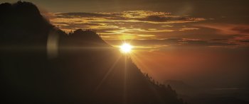 Movie still from “Monsters of Man” (2020), directed by Mark Toia – The sun is setting over a mountain range; Extreme Wide shot, Low angle