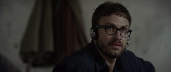 Movie still from “Monsters of Man” (2020), directed by Mark Toia – A person wearing headphones; Close Up shot, Over the shoulder angle
