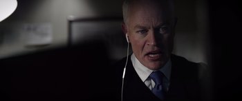 Movie still from “Monsters of Man” (2020), directed by Mark Toia – An older man wearing a suit and tie while listening to headphones; Close Up shot, Over the shoulder angle