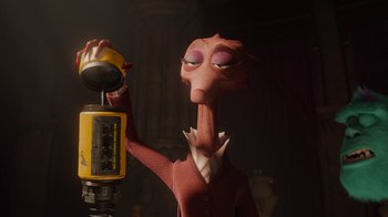 Movie still from “Monsters University” (2013), directed by Dan Scanlon – An animated character is holding a phone up; Medium shot, Low angle