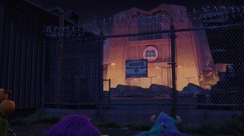 Movie still from “Monsters University” (2013), directed by Dan Scanlon – A chain link fence that has a sign on it; Extreme Wide shot, Low angle