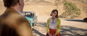 Movie still from “Monstrous” (2022), directed by Chris Sivertson – A woman standing in front of an old blue truck; Medium shot, Over the shoulder angle