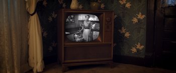 Movie still from “Monstrous” (2022), directed by Chris Sivertson – An old television with a picture of a woman and a baby; Medium shot, High angle