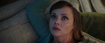 Movie still from “Monstrous” (2022), directed by Chris Sivertson – A person laying on a couch; Close Up shot, Overhead angle