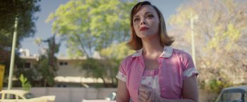 Movie still from “Monstrous” (2022), directed by Chris Sivertson – A woman in a pink shirt and white polka dot shirt; Close Up shot, Over the shoulder angle