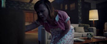 Movie still from “Monstrous” (2022), directed by Chris Sivertson – A woman in a pink shirt and a polka dot skirt; Medium shot, Low angle