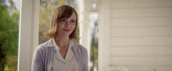 Movie still from “Monstrous” (2022), directed by Chris Sivertson – A woman standing in front of a white building; Close Up shot, Over the shoulder angle