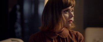 Movie still from “Monstrous” (2022), directed by Chris Sivertson – A person wearing a brown jacket; Close Up shot, Over the shoulder angle