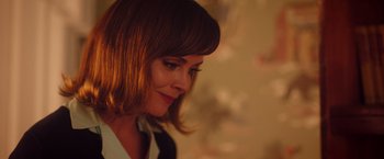 Movie still from “Monstrous” (2022), directed by Chris Sivertson – A person wearing a suit and tie; Close Up shot, Over the shoulder angle