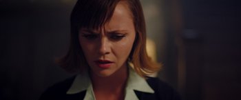 Movie still from “Monstrous” (2022), directed by Chris Sivertson – A person wearing a suit; Close Up shot, High angle