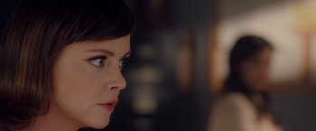 Movie still from “Monstrous” (2022), directed by Chris Sivertson – A woman's face in a dark room; Close Up shot, Over the shoulder angle